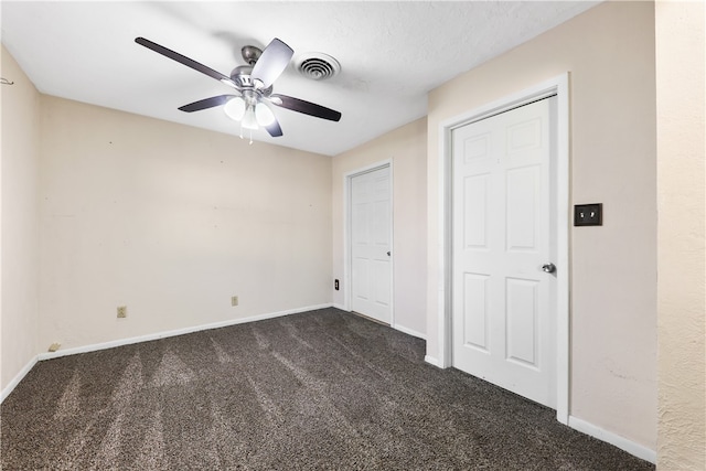 unfurnished bedroom featuring a textured ceiling, dark colored carpet, and ceiling fan