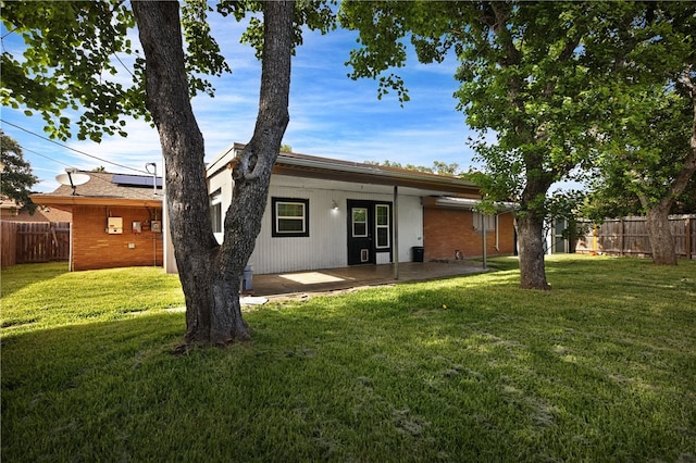 back of property featuring a patio and a lawn