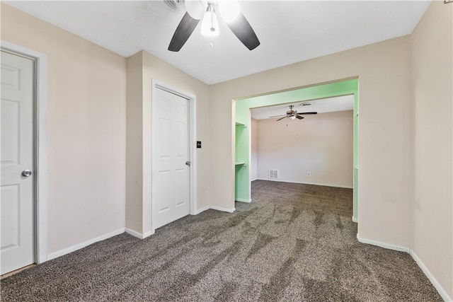 spare room with ceiling fan and dark carpet