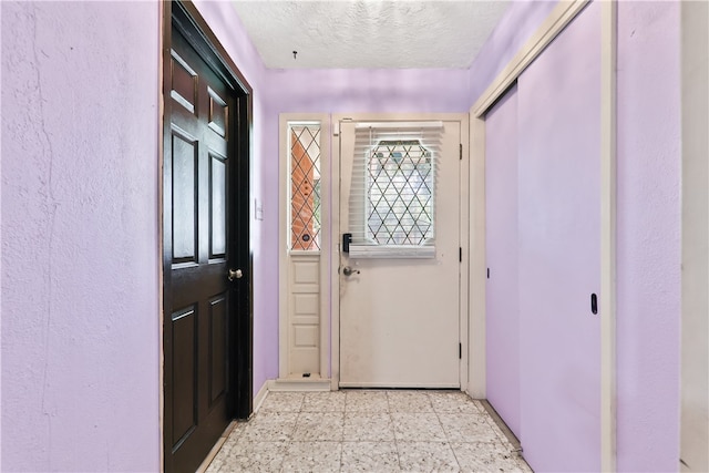 doorway with a textured ceiling