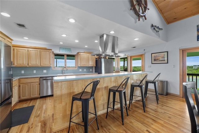 178 Smyth St, Port Oconnor, TX 77982 - kitchen featuring stainless steel appliances, island exhaust hood, light brown cabinetry, light countertops, and recessed lighting