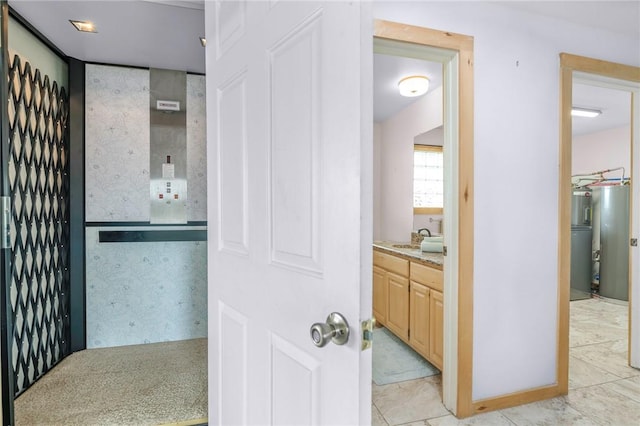 178 Smyth St, Port Oconnor, TX 77982 - hallway with electric water heater, a sink, and light tile patterned floors