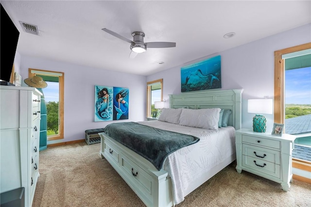 178 Smyth St, Port Oconnor, TX 77982 - bedroom with light colored carpet, multiple windows, ceiling fan, and baseboards