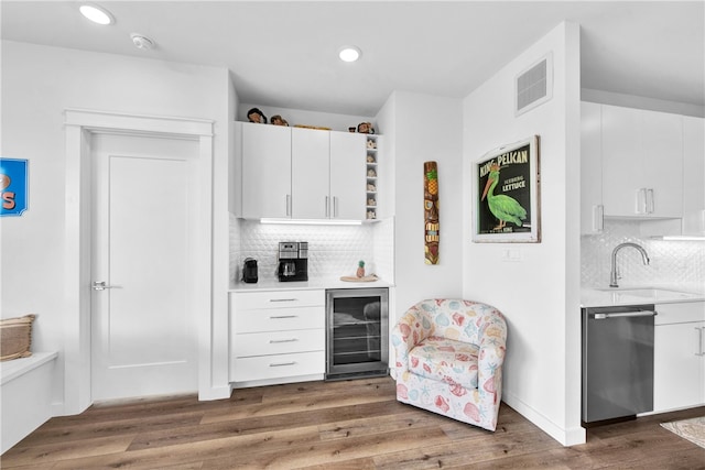 bar with dark wood-type flooring, white cabinetry, wine cooler, and dishwasher