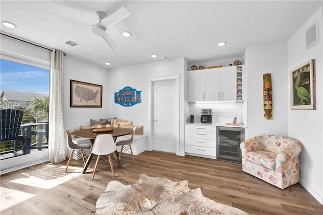 interior space featuring white cabinetry, wood-type flooring, ceiling fan, and beverage cooler