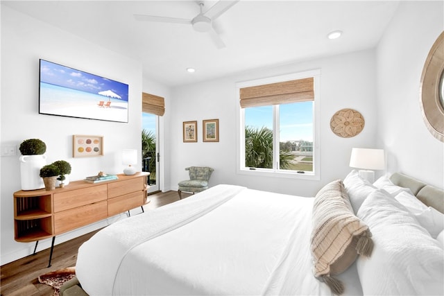 bedroom featuring ceiling fan, wood-type flooring, and multiple windows