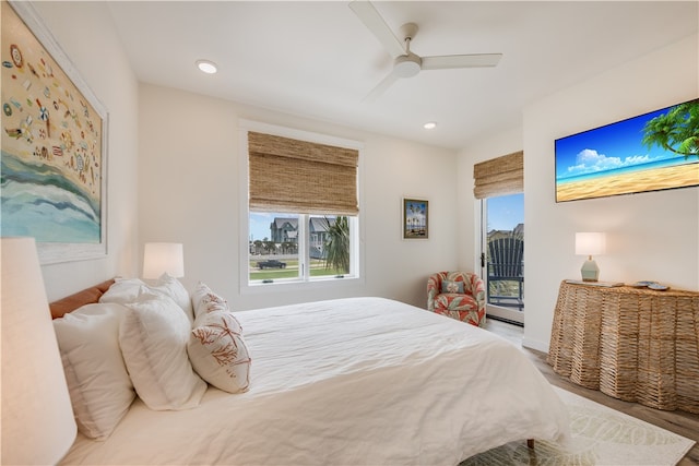 bedroom featuring hardwood / wood-style floors, access to outside, multiple windows, and ceiling fan