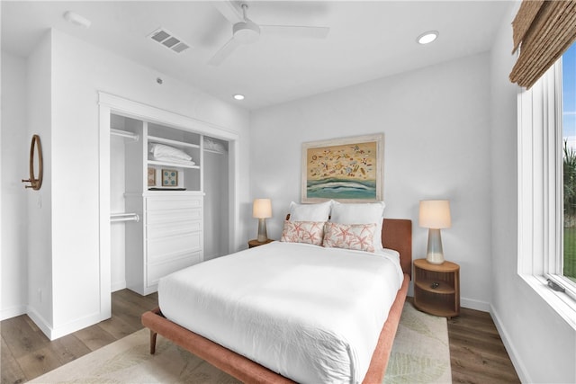 bedroom with dark wood-type flooring, a closet, and multiple windows