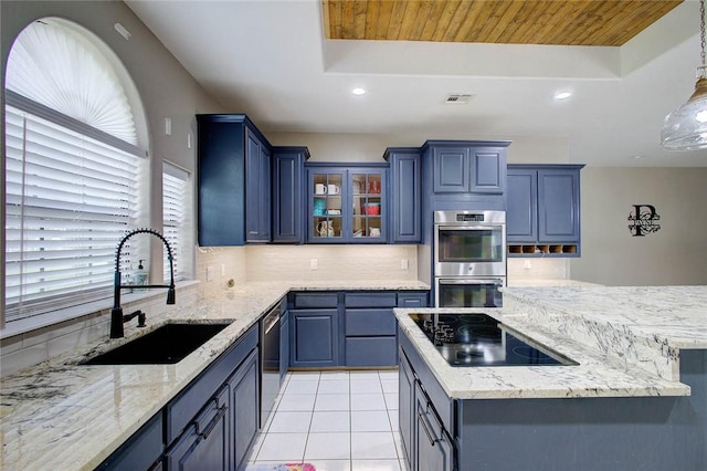 2111 Buckeye Dr, Ingleside, TX 78362 - kitchen featuring stainless steel appliances, a sink, backsplash, a kitchen island, and blue cabinets