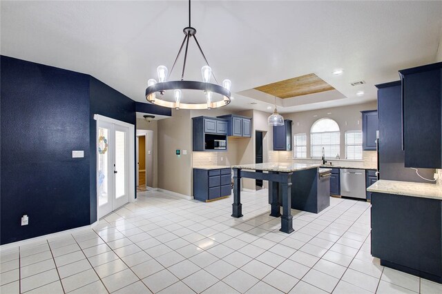 kitchen with a center island, hanging light fixtures, stainless steel dishwasher, and a raised ceiling