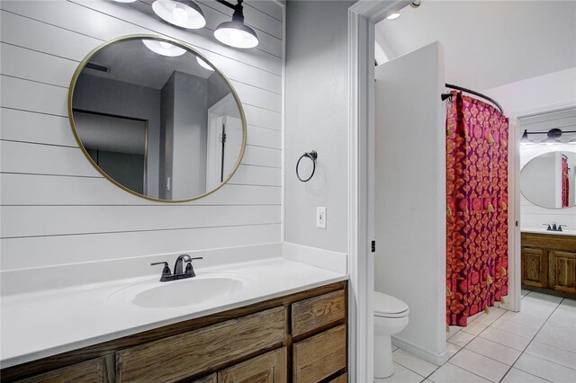 bathroom with toilet, vanity, tile patterned flooring, and walk in shower