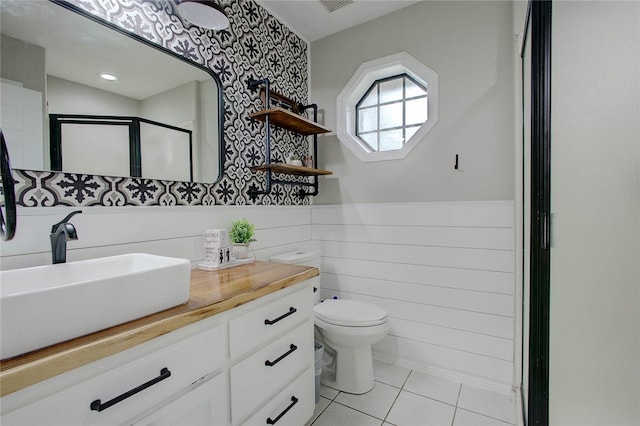 bathroom with walk in shower, tile patterned flooring, vanity, and toilet