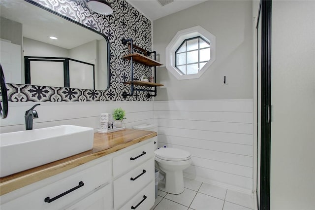 2111 Buckeye Dr, Ingleside, TX 78362 - full bathroom with a stall shower, toilet, wallpapered walls, a wainscoted wall, and vanity