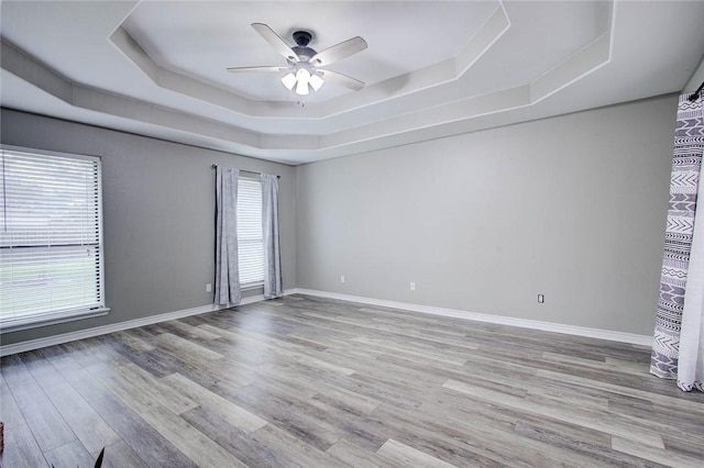2111 Buckeye Dr, Ingleside, TX 78362 - empty room featuring a tray ceiling, a ceiling fan, wood finished floors, and baseboards