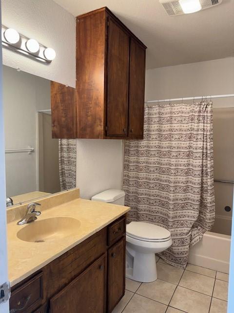 full bathroom featuring shower / tub combo with curtain, tile patterned floors, toilet, and vanity