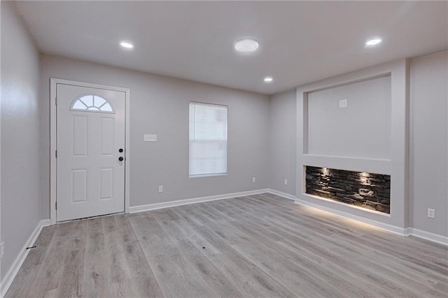 foyer featuring baseboards, recessed lighting, a wealth of natural light, and light wood-style floors