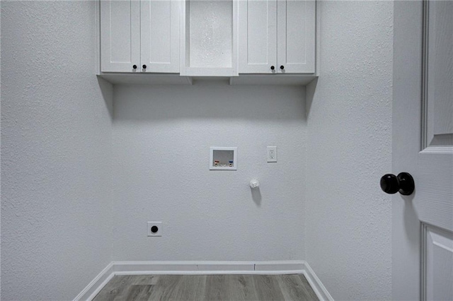 clothes washing area featuring hookup for a washing machine, baseboards, light wood-type flooring, cabinet space, and electric dryer hookup