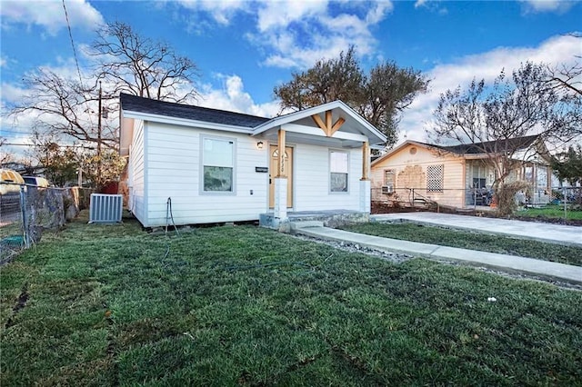 bungalow-style house featuring fence, cooling unit, and a front yard