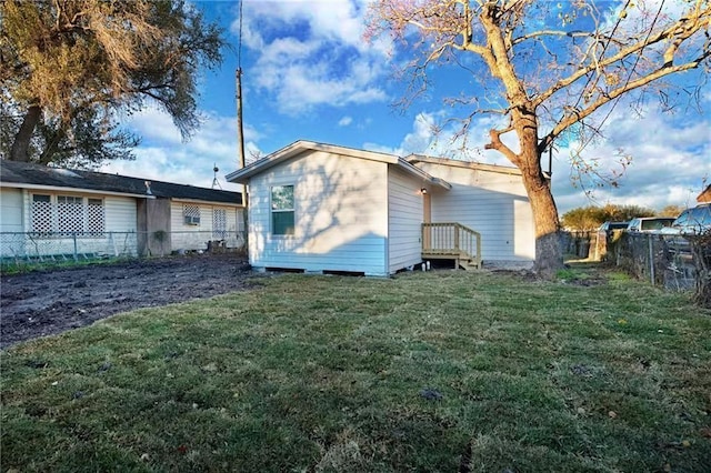 rear view of house featuring a lawn and a fenced backyard