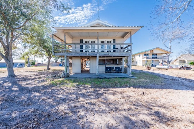 back of house with a wooden deck and a patio area