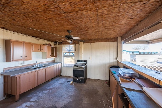 kitchen featuring electric stove, sink, wooden walls, and ceiling fan