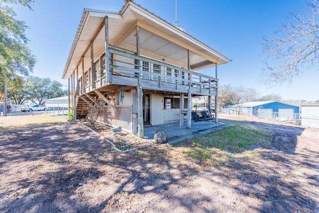 rear view of property featuring a patio and a deck