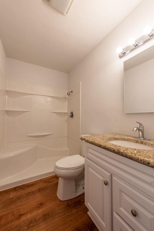 bathroom with toilet, hardwood / wood-style flooring, a shower, and vanity