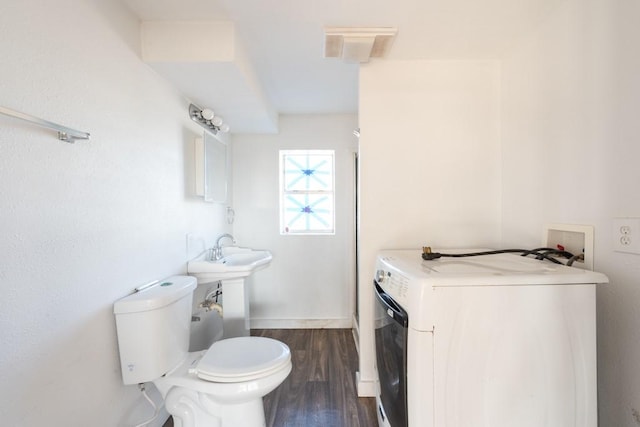 bathroom featuring washer / clothes dryer, hardwood / wood-style floors, and toilet