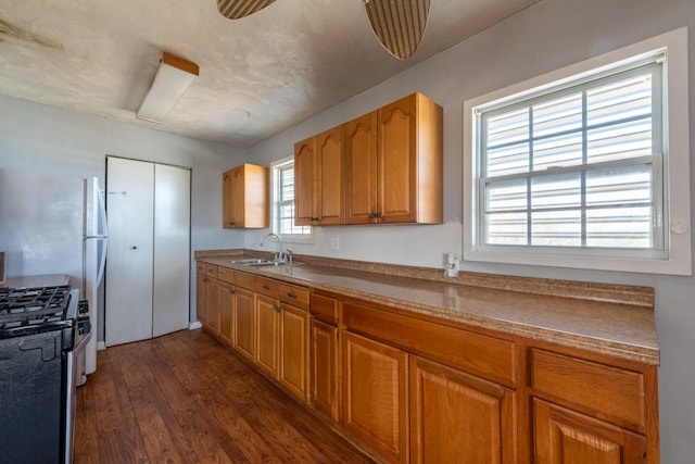 kitchen featuring sink, gas range, and dark hardwood / wood-style flooring