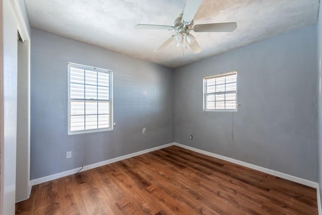 spare room with ceiling fan and dark hardwood / wood-style flooring