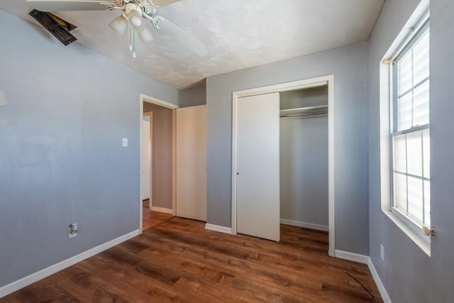 unfurnished bedroom featuring ceiling fan, a closet, and dark hardwood / wood-style flooring