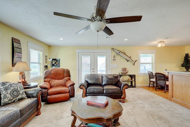 living room featuring ceiling fan, a textured ceiling, and french doors