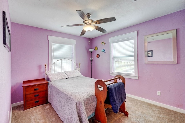 carpeted bedroom featuring ceiling fan and multiple windows