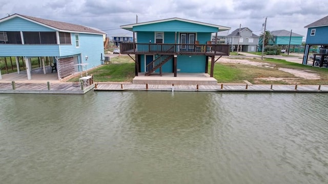 view of dock featuring a deck with water view and a yard