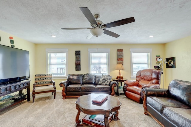 living room featuring light carpet, a textured ceiling, and ceiling fan