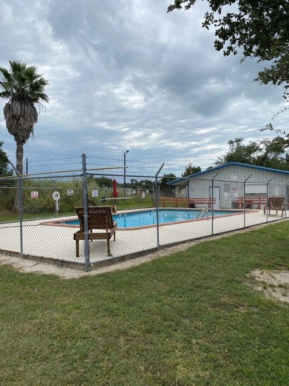 view of swimming pool featuring a lawn