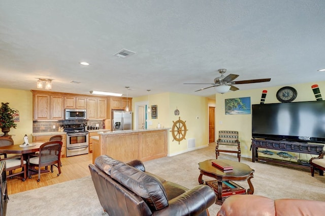 carpeted living room with ceiling fan and a textured ceiling