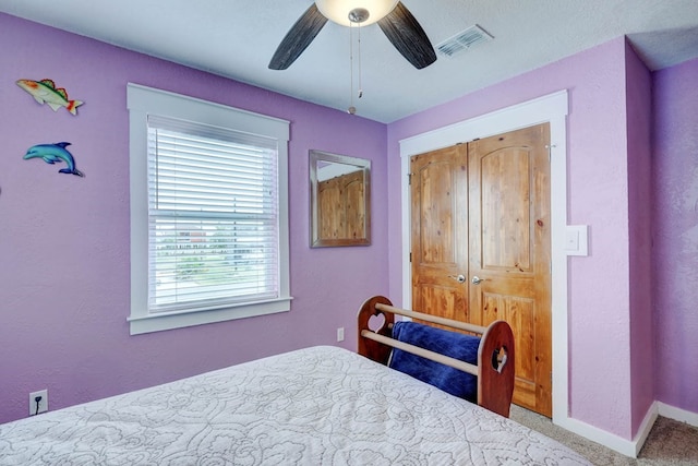 carpeted bedroom featuring a closet and ceiling fan