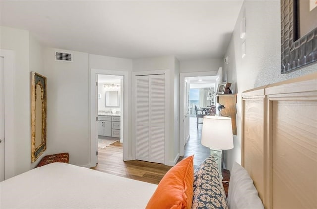 bedroom featuring connected bathroom, a closet, and light wood-type flooring