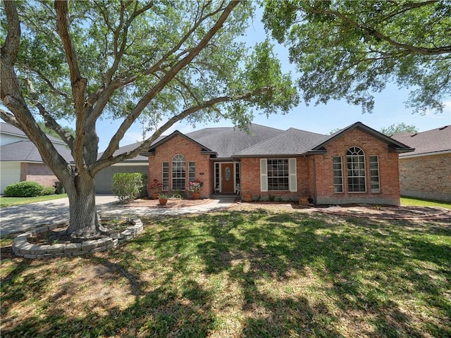 ranch-style house with brick siding, a shingled roof, a front yard, a garage, and driveway