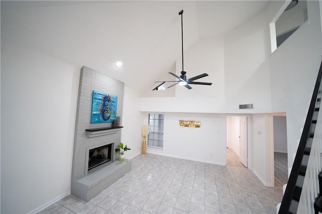 unfurnished living room featuring high vaulted ceiling, a large fireplace, and ceiling fan