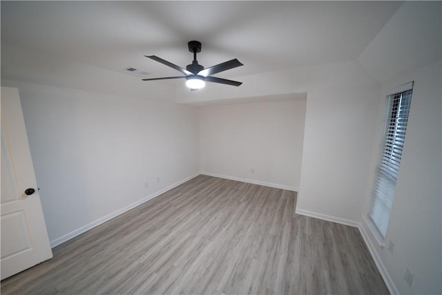 empty room with ceiling fan and light hardwood / wood-style flooring