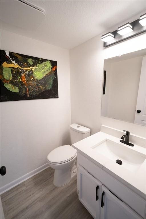 bathroom featuring vanity, toilet, and hardwood / wood-style floors