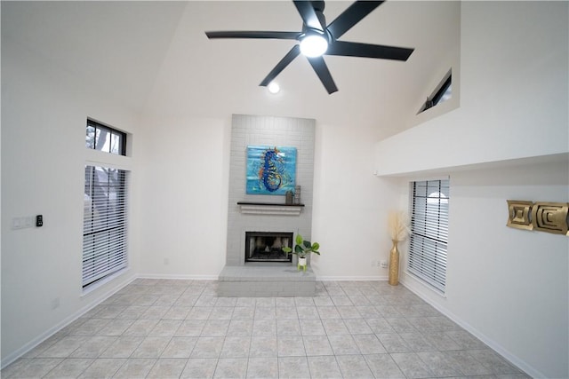 unfurnished living room featuring light tile patterned floors, a fireplace, high vaulted ceiling, and ceiling fan