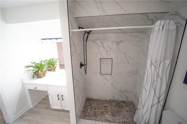 bathroom with hardwood / wood-style flooring and a shower with shower curtain