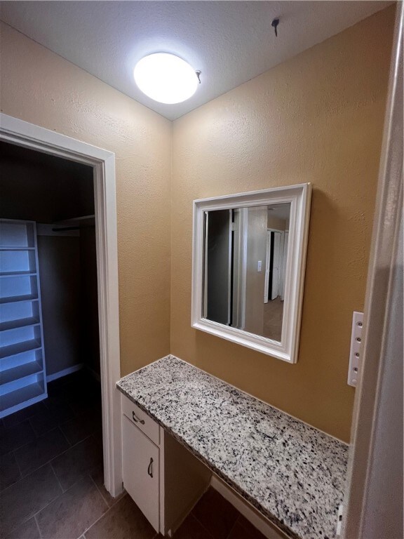 bathroom featuring vanity, a textured ceiling, and tile patterned floors