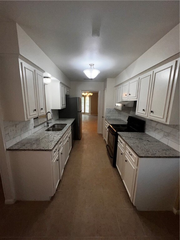 kitchen with white cabinets, black electric range oven, and sink