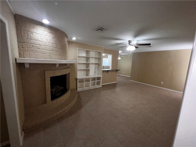 unfurnished living room with a brick fireplace, ceiling fan, and a textured ceiling