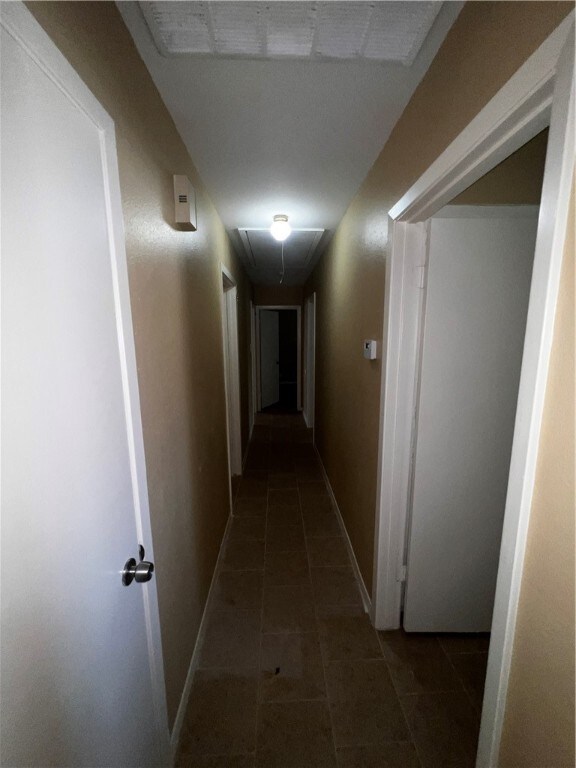 hall with dark tile patterned floors