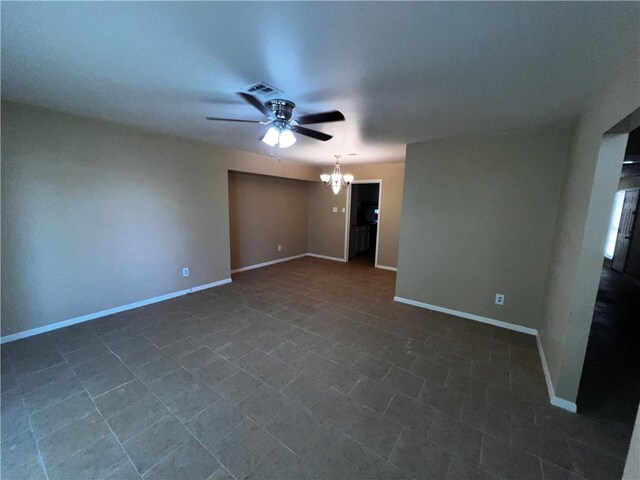 spare room featuring ceiling fan with notable chandelier